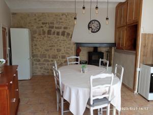 a kitchen with a table with chairs and a fireplace at Gites Terre et Ciel in Largentière