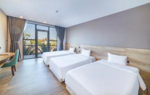 2 camas en una habitación de hotel con ventana en Hafi Beach Hotel en Vung Tau
