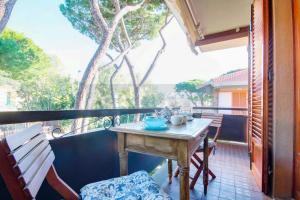 a balcony with a table and a bench on a porch at Mare appartamento ristrutturato e con posto auto in Castiglione della Pescaia