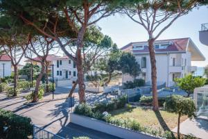 una fila de casas con árboles en primer plano en Mare appartamento ristrutturato e con posto auto en Castiglione della Pescaia