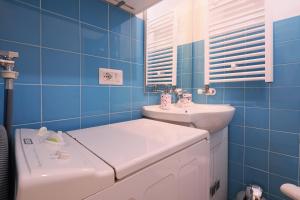 baño de azulejos azules con lavabo y aseo en PrimoPiano - Buccinasco en Buccinasco