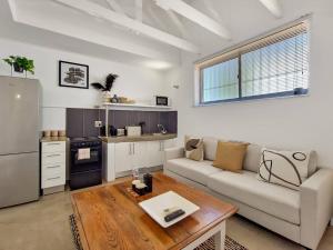 een woonkamer met een bank en een tafel bij Unique Studio Close to Promenade in Kaapstad