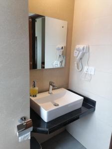 a bathroom with a white sink and a mirror at Urban Boutique Hotel Pokhara in Pokhara