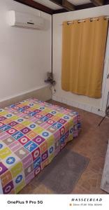 a bedroom with a bed with a colorful comforter at Appartement charmant à Rivière-Pilote - 30 m² avec terrasse in Rivière-Pilote