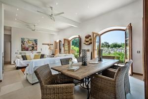 uma sala de estar com uma mesa de jantar e uma cama em Casa da Terra Branca em Vila Nova de Cacela