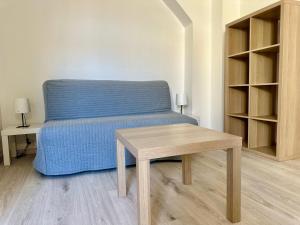 um quarto com uma cama azul e uma mesa de madeira em 02 Studio Immeuble Le GD em Jarny