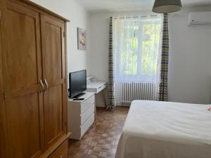 a bedroom with a bed and a tv on a dresser at Superbe Villa Piscine Le Céladore de Sarlat Climatisé, 7 Min à pied du Centre in Sarlat-la-Canéda