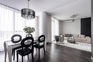 een woonkamer met een eettafel en stoelen bij cohost I HighRise 65m2 Apt w- Balcony and garage parking, Self check-in in Vilnius