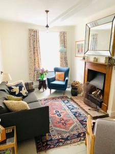 a living room with a couch and a fireplace at The Yellow cottage on the hill. in Framlingham