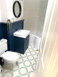 a bathroom with a white toilet and a sink at The Yellow cottage on the hill. in Framlingham