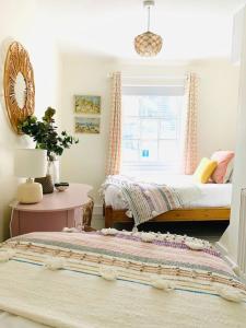 a bedroom with a bed and a table and a window at The Yellow cottage on the hill. in Framlingham