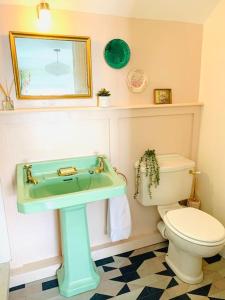 a bathroom with a sink and a toilet at The Yellow cottage on the hill. in Framlingham