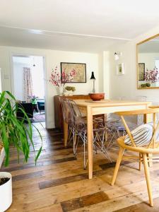 a dining room with a wooden table and chairs at The Yellow cottage on the hill. in Framlingham