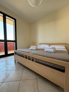 Cama grande en habitación con ventana grande en Oasi Kite - Stagnone Apartments en Birgi Vecchi