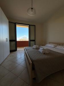 um quarto com 2 camas e uma grande janela em Oasi Kite - Stagnone Apartments em Birgi Vecchi