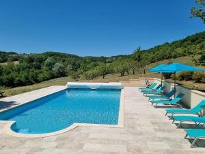a swimming pool with lounge chairs and umbrellas at Les Collines du Quercy Blanc in Castelnau-de-Montratier