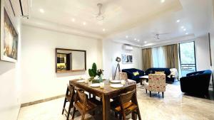 sala de estar con mesa y comedor en BluO 3BHK CityWalk Mall, MAX Saket -Lift, Balcony., en Nueva Delhi