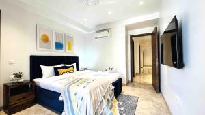 1 dormitorio con 1 cama y TV de pantalla plana en BluO 3BHK CityWalk Mall, MAX Saket -Lift, Balcony., en Nueva Delhi