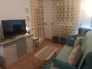 ein Wohnzimmer mit einem Sofa und einem TV in der Unterkunft El Calon, mar y montaña in Cuevas del Almanzora