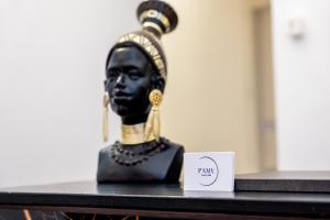 una estatua negra y dorada sobre una mesa con una tarjeta en PAMA Luxury Suite & Spa, en Nápoles