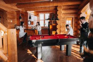 un gruppo di persone che giocano a biliardo in una stanza con tavolo da biliardo di Private Hot Tub Sauna Ski Indoor Pool Nyctale a Mille-Isles