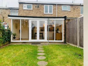 uma extensão a uma casa com portas de vidro deslizantes em New Modern house in Reading with free parking em Caversham