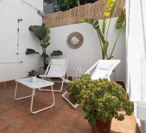 two chairs and a table on a patio with plants at Stylish Apartment with Terrace for Couple or Family in Barcelona