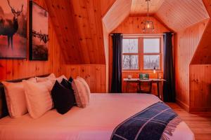 a bedroom with a bed in a wooden room at Private Hot Tub Sauna Ski Indoor Pool Nyctale in Mille-Isles +63 photos