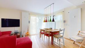 a living room with a table and a red couch at Villa am Kurpark in Binz