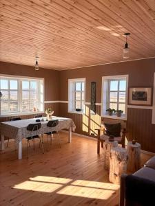 sala de estar con mesa, sillas y ventanas en Jóhannshús- tradational Icelandic house, en Hrepphólar