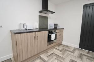a kitchen with wooden cabinets and a stove at Matlock Studio 7 - Coventry in Coventry