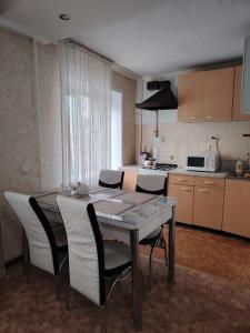 uma cozinha com uma mesa e cadeiras e uma mesa e uma cozinha em Апартамент в центре города em Oral