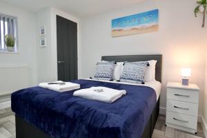 a bedroom with a large bed with towels on it at Matlock Studio 7 - Coventry in Coventry