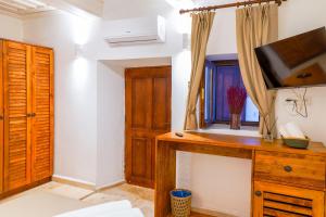 a room with a tv on a wooden dresser at NİYAMA MARİNA Butik Hotel in Çeşme