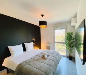 a bedroom with a large bed with a teddy bear on it at Marcenac - T2 en Résidence, Clim, Parking, terrasse in Sète