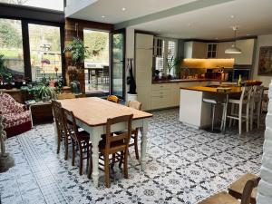 cocina y sala de estar con mesa y sillas en Les Volets Blancs, en Braine-le-Comte