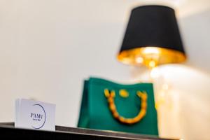 una lámpara y una bolsa verde junto a una vela en PAMA Luxury Suite & Spa en Nápoles