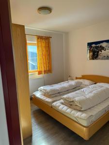 a bedroom with two beds and a window at Weinzeit Chalet & Appartements in Königsleiten