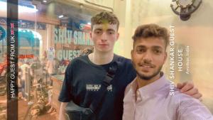 twee jonge mannen die voor een winkel staan bij Shiv Shankar Guest House in Amritsar