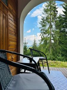 a porch with two chairs and a table and a window at Chata Kokava Línia tour 2 in Kokava na Rimavica