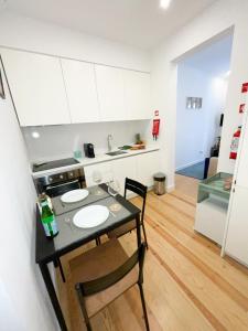 une petite cuisine avec une table et un évier dans l'établissement Lisbon Charming Santos Apartment w/ Patio, à Lisbonne
