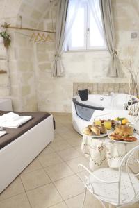 un baño con una cama y una mesa con comida. en Antica Mateola en Matera