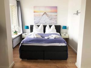 1 dormitorio con 1 cama grande con almohadas blancas en Ferienwohnung in Westerdeichstrich, en Stinteck