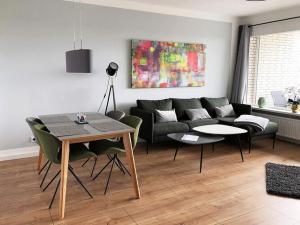 uma sala de estar com um sofá e uma mesa em Ferienwohnung in Westerdeichstrich em Stinteck