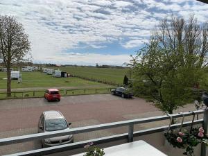 vistas a un aparcamiento con coches aparcados en Ferienwohnung in Westerdeichstrich, en Stinteck