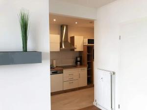 una cocina con armarios blancos y una maceta en Ferienwohnung in Westerdeichstrich, en Stinteck