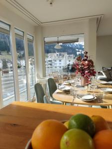 un comedor con mesas, sillas y ventanas en Superior Apartment en Engelberg