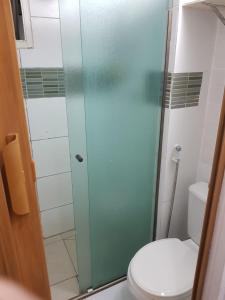 uma casa de banho com uma cabina de duche em vidro e um WC. em Quarto no Jd. Satélite - Excelente localização na Zona Sul em São José dos Campos