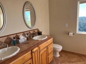 a bathroom with two sinks and a toilet and a mirror at Stunning Mountaintop Resort in Placerville