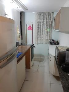 eine kleine Küche mit Spüle und Kühlschrank in der Unterkunft Quarto no Jd. Satélite - Excelente localização na Zona Sul in São José dos Campos
